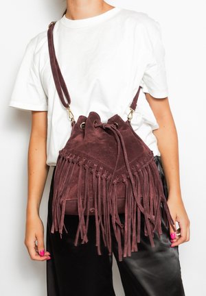Borsa a secchiello in suede viola con dettagli in frange, chiusura con coulisse e tracolla regolabile. Texture liscia con elementi hardware in contrasto.