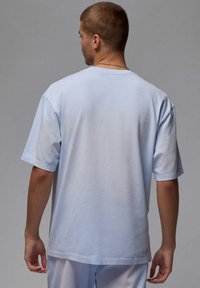 T-shirt di cotone azzurro chiaro con maniche corte, vestibilità rilassata e colletto tondo. Texture liscia, senza motivi o grafica visibili.