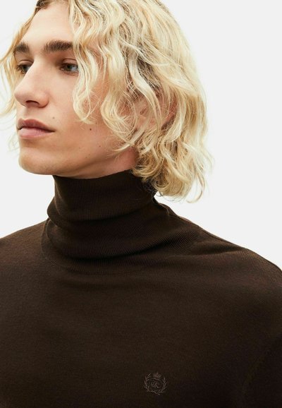 Brauner Rollkragenpullover aus Rippstoff, mit einem dezenten Logo auf der Brust, in einer figurbetonten Passform und glatter Textur.