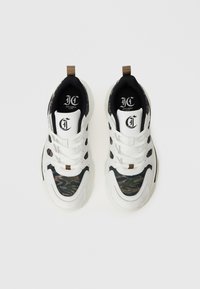 Ein Paar weiße und camouflierte Schnürsneaker mit Logo an der Zunge und schwarzem Innenfutter auf einem weißen Hintergrund.