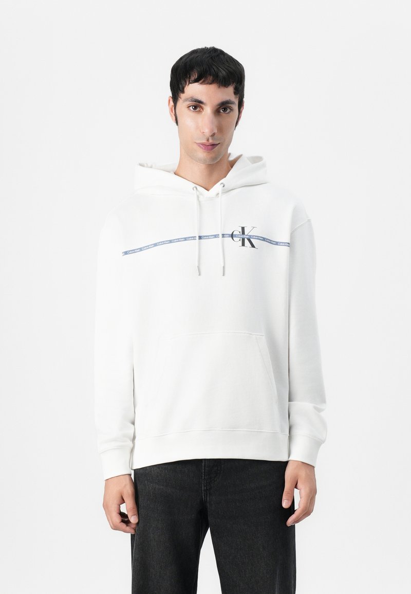 Witte hoodie met een trekkoord, een voorzak en het CK-logo op de linkerborst. Heeft een marineblauwe streep en een zachte, gestructureerde stof.