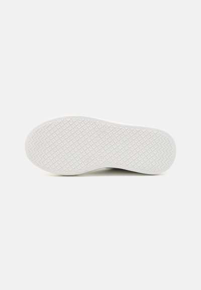 Schuhsohle mit einem strukturierten weißen Gummidesign, das ein welliges Zickzackmuster und kleine erhabene Akzente für Grip und Traktion aufweist.