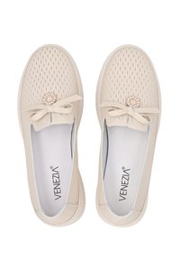 Beige geperforeerde schoenen met een decoratieve strik en ronde accent. Glad interieur en rubberen zool. Merklogo zichtbaar op de binnenzool.