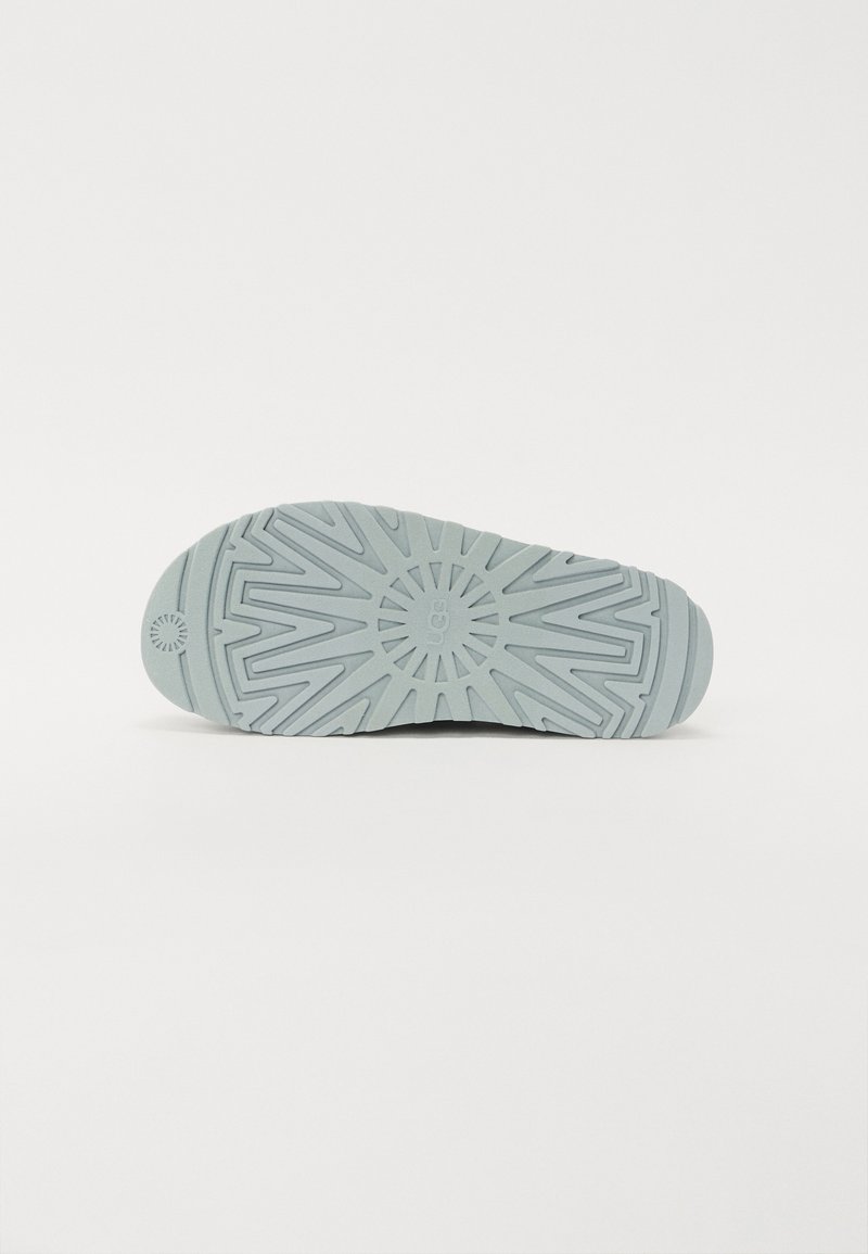 Suola della scarpa realizzata in materiale gommoso blu chiaro, caratterizzata da un motivo geometrico testurizzato e da un battistrada prominente per una presa migliore. Design con punta arrotondata.