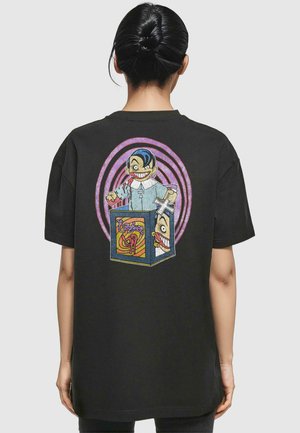 Black cotton t-shirt featuring a graphic print of a smiling character and a jack-in-the-box, with vibrant colors and circular patterns.