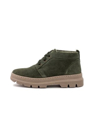 Botas de tobillo de ante verde con punta redondeada, dos ojales texturizados y una suela de goma resistente de color marrón claro. Diseño minimalista con detalles de costura.