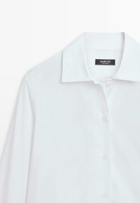 Hvid langærmet skjorte med knapper og spidst krave, delvist knappet, mærket Massimo Dutti, vist på en hvid baggrund.