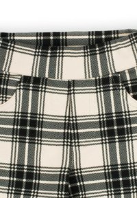 Czarno-biała tkanina w kratę z wzorem w kratkę, kieszeniami i paskiem w talii. Materiał wydaje się gładki, o wyraźnej strukturze.