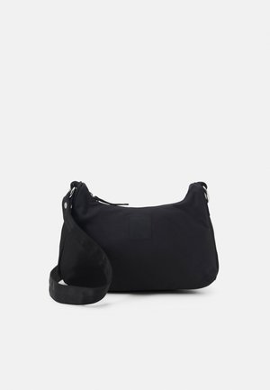 Sort skuldertaske i nylon med justerbar rem, lynlåslukning og enkel rektangulær form mod en ensfarvet lys baggrund.