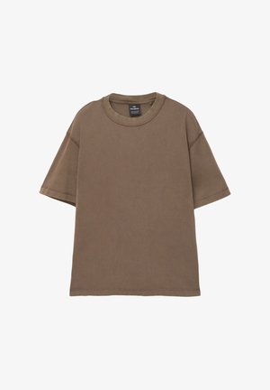 Tricou oversized, de culoare maro, fabricat din bumbac moale, cu guler rotund, mâneci scurte și detalii de cusătură vizibile pe toată suprafața.