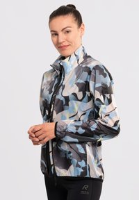 Chaqueta ligera y multicolor con un patrón de camuflaje en tonos de azul, gris y amarillo. Tiene un cuello alto y cierre de cremallera.