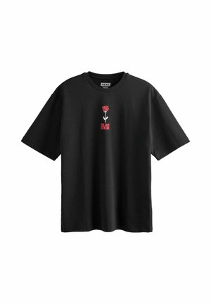 T-shirt noir à manches courtes avec un petit motif de rose rouge et un texte rouge "THE LAST STRIKE" centré sur la poitrine.