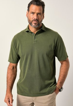 Polo de color verde oliva con una superficie texturizada, tapeta de tres botones, mangas cortas y una costura visible a lo largo del borde inferior.