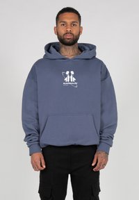 Hooded sweatshirt in navy blue cotton with a front pocket. Features a white graphic print logo at the chest. Ribbed cuffs and hem.