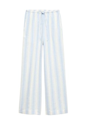 Salopette leggera a righe con vita peplo, profonda scollatura a V e laccetti regolabili sul davanti in blu e bianco. Indossata con una borsa intrecciata.