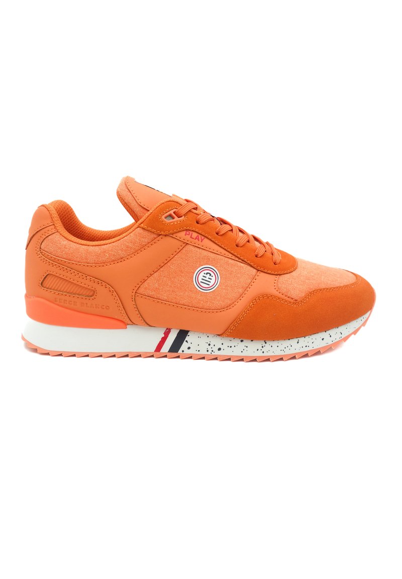 Oranje sneaker met een textuurstof bovenwerk, suede accenten, roze details en een gespoten witte tussenzool met rode en zwarte strepen.