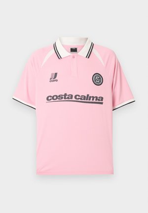 Polo rose avec col et manches à rayures noires et blanches, arborant le texte « costa calma » et un logo circulaire sur la poitrine.