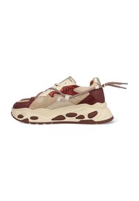 Sneakers with a beige upper, red accents, and metallic detailing. Thick, textured sole with cut-out sections and striped laces.
