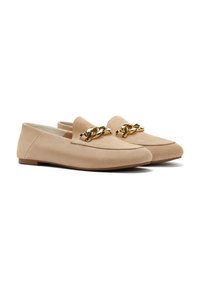 Beige Wildleder Slipper mit flacher Sohle, versehen mit einer dekorativen goldenen Kette über der Vorderseite und einer glatten Textur. Abgerundetes Zehendesign.