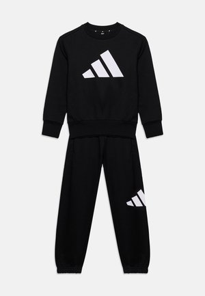 Czarny komplet bluzy z długim rękawem i spodni z białym logo Adidas na piersi i lewym nogawce, ułożony płasko na białym tle.