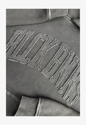 Grijze sweatshirt met verhoogde borduring waarop "BLCK BNS" staat. Heeft ribgebreide cuffs en een zachte, gestructureerde stof met een casual fit.