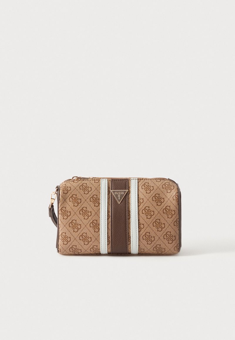 Portefeuille-pochette Guess marron et beige avec motif monogramme, fermeture éclair dorée, bracelet latéral, rayures blanches verticales et logo triangulaire au centre avant.
