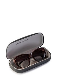 Okulary przeciwsłoneczne polaryzacyjne w kształcie kocich oczu z ciemnobrązowymi szkłami, w czarnym teksturowanym etui ochronnym o szarym wnętrzu.