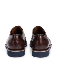 Bruine leren schoenen met een gestructureerd, geweven achterpaneel en een contrasterende blauwe rubberen zool. Gladde afwerking met een afgeronde puntvorm.