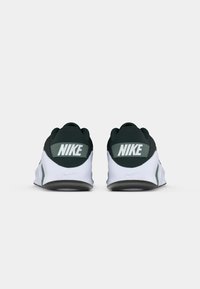 Nike-sneakers med en sort og hvid farveskala; har en polstret grøn krave, logo på hælen, hvid mellemsål og tekstureret sort ydersål.