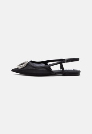 Black pointed-toe slingback flat shoe with silver buckle detail on front and thin adjustable ankle strap.