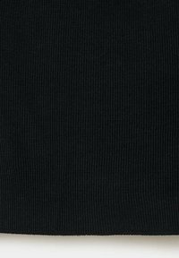 Gros plan d'un tissu tricoté côtelé noir montrant un motif texturé vertical et de fines finitions de couture.
