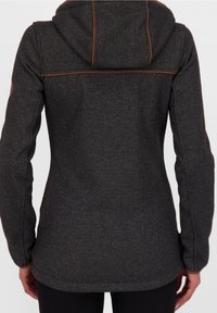 Dámská tmavě šedá mikina s kapucí z texturované tkaniny, nastavitelnou kapucí a kontrastním oranžovým prošitím. Má štíhlý design a přiléhavý střih.