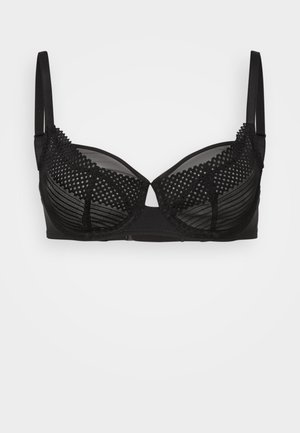 Black bra with sheer dotted mesh overlay, underwire cups, adjustable straps, and a smooth band. Features textured accents and a classic design.