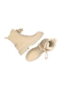 Beige mockaskinnankor med en strukturerad yta, snörning framtill, mjukt foder och en gummisula med ett räfflat mönster för bättre grepp.