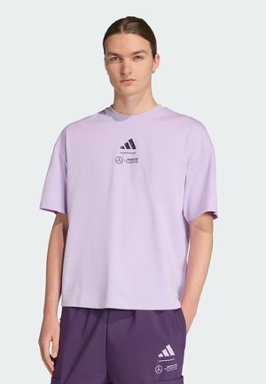 Light purple cotton oversized t-shirt with a crew neck, featuring black Adidas and Mercedes logos on the chest. Short sleeves.