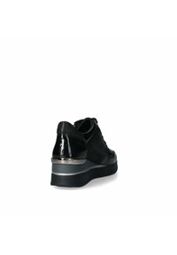 Sneaker nera con sezioni in vernice e camoscio, dotata di un tacco spesso con accenti metallici e una suola imbottita per il massimo comfort.