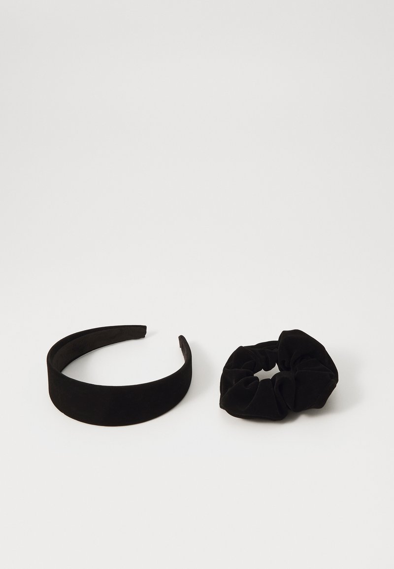 Črna sametasta naglavna traku z gladkim, širokim dizajnom ob strani in ujemajoča se črna sametasta scrunchie z nabranim teksturo.