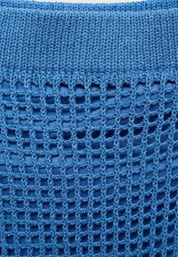 Tissu tricoté bleu avec un motif en maille ouverte dans la section inférieure, présentant un col côtelé bleu uni. Texture douce, aspect léger.