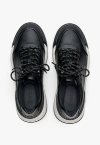 Czarne skórzane sneakersy o gładkiej teksturze i zaokrąglonym nosku, z czarnymi sznurowadłami i kontrastującą białą podeszwą. Minimalistyczny design.