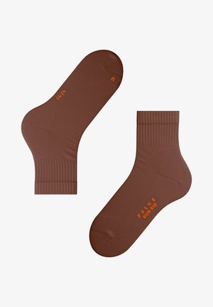 Chaussettes de cheville marron en matière lisse avec des bords côtelés. Présentent un logo orange et des détails de taille sur le dessus.