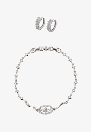 Sieradenset in zilverkleur met een ovale hanger met een bloemmotief en heldere kristallen, aangevuld met bijpassende oorringen.