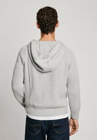 Hallhalli hallitusseente musteriga hall ribapinda kootud kapuutsiga sviiter, millel on avar kapuuts ja pikad varrukad. Omab tekstureeritud mustrit ja vöökoha juures mugavat lõiget.