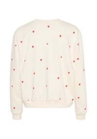 Krämfärgad sweatshirt med spridda röda hjärtan, ribbad rund hals, stretchiga muddarna och en figurnära midja. Mjuk textur.