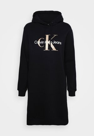 Vestito felpa nero con cappuccio a maniche lunghe, tasca frontale e grande logo Calvin Klein Jeans beige e bianco sul petto.