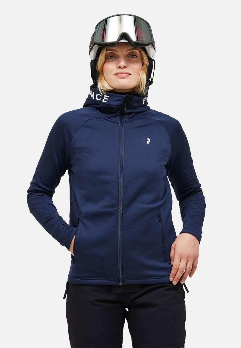 Navy blue ski jacket with a high collar, zip closure, and two side pockets. Features a hood with "FRANCE" lettering. Smooth texture.