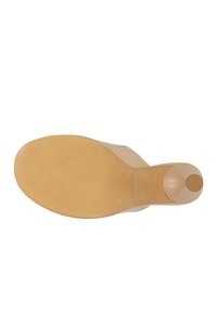 La suola della scarpa con tacco beige mostra una suola in gomma testurizzata, presenta un tacco arrotondato e un marchio impresso, progettata per stabilità e grip.