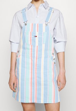 Pruhované denimové šaty na šle v pastelových barvách, s nastavitelnými ramínky, přední kapsou a postranními knoflíkovými detaily.