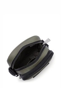 Pochette circolare di colore verde oliva con dettagli neri; esterno testurizzato, interno liscio, dotata di una cerniera argentata.