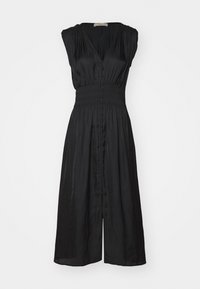 Robe noire avec un décolleté en V, des manches courtes et une taille smockée. Dotée d'une fermeture à boutons sur le devant et d'une jupe fluide arrivant au genou. Textile doux.