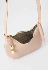Borsa a tracolla in pelle beige con forma curva, zip e accessori dorati, tracolla regolabile e interno foderato in tessuto con etichetta logo.